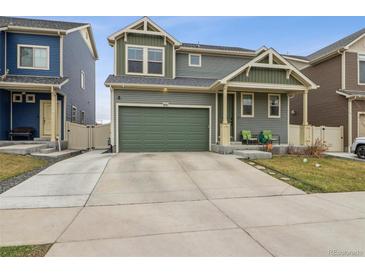 Two-story home with a gray exterior, green accents, and a spacious two-car attached garage at 18108 E 52Nd Ave, Denver, CO 80249