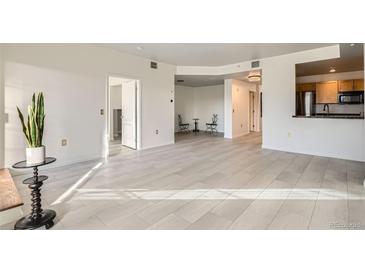 Open living room featuring modern floors and a kitchen view, perfect for entertaining at 300 W 11Th Ave # 4F, Denver, CO 80204