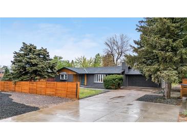 Charming single-story home with a spacious driveway, mature trees, and a privacy fence at 2320 S Valley Hwy, Denver, CO 80222