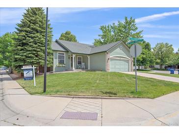 Charming single-story home with well-manicured lawn and an attached two-car garage at 9406 Troon Village Way, Lone Tree, CO 80124