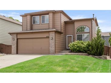 Charming two-story home features a well-maintained lawn and an attached two-car garage at 10591 Hyacinth St, Highlands Ranch, CO 80129