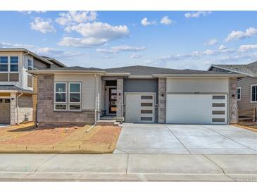 Charming single Gathering home with an attached two car garage and stone accents on the facade at 8672 Pennycress Dr, Littleton, CO 80125