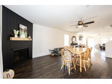 Open-concept living room with black fireplace, wood floors, and dining area at 1786 Quartz St, Castle Rock, CO 80109