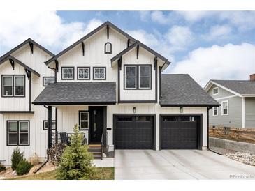 Striking two-story home featuring white siding, black trim, and a two-car garage at 2020 Teller St, Lakewood, CO 80214