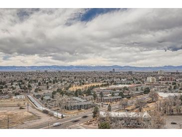 Expansive aerial view showcasing the city and the distant snow-capped mountains under a cloudy sky at 7865 E Mississippi Ave # 1501, Denver, CO 80247