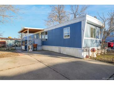 Charming blue and white exterior with covered porch and well-maintained landscaping at 1500 W Thornton Pkwy # 163, Thornton, CO 80260