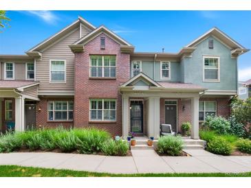 Charming townhome featuring a brick facade, well-maintained landscaping, and inviting front porch at 767 Roslyn St # 20, Denver, CO 80230