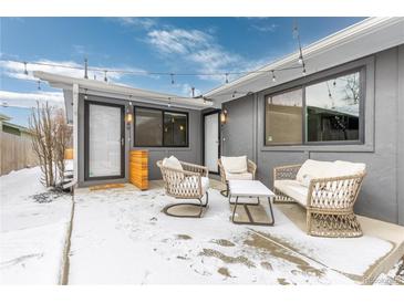 Cozy patio area with stylish furniture, string lights, and gray exterior, perfect for outdoor relaxation in a winter setting at 47 S Hazel Ct, Denver, CO 80219