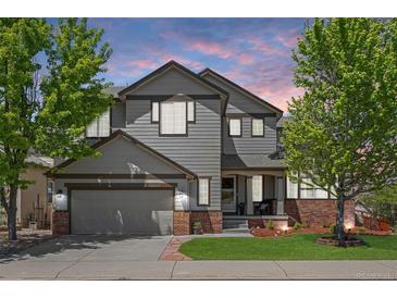 Charming two-story home with a well-manicured lawn, brick accents, and a two-car garage, perfect for suburban living at 4467 Trailside Ln, Castle Rock, CO 80109