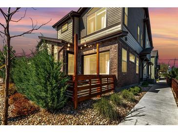 Beautiful brick and siding exterior with a wooden deck and lush landscaping at sunset at 6396 Nelson Ct, Arvada, CO 80004