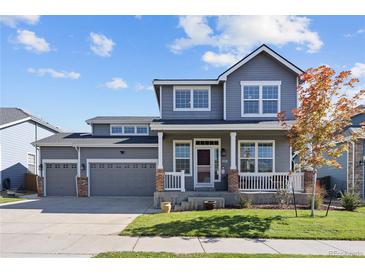 Charming two-story home featuring a covered front porch and a three-car garage at 338 Mt Wilson St, Brighton, CO 80601