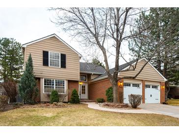 Charming two-story home with a brick facade, attached two car garage, and beautifully landscaped front yard at 7743 S Jersey Way, Centennial, CO 80112