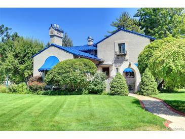 Charming home featuring a blue tile roof, stucco walls, and lush landscaping at 6 Ivy Ln, Denver, CO 80220