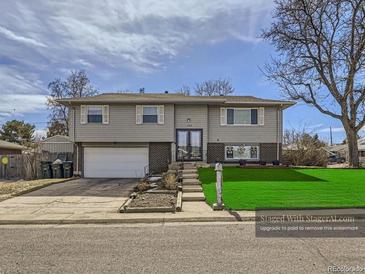 Charming two-story home featuring a well-manicured lawn and attached garage on a sunny day at 1488 W 102Nd Ave, Northglenn, CO 80260