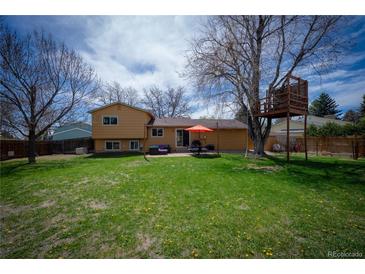 Large backyard with mature tree and custom treehouse, plus a patio and grill for easy entertaining at 1562 Madison Ct, Louisville, CO 80027
