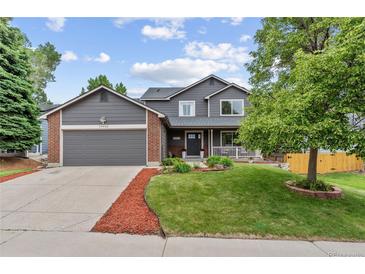Charming two-story home featuring a well-manicured lawn, gray siding, brick accents and an attached two-car garage at 19935 E Stanford Dr, Centennial, CO 80015