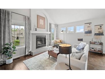 Bright living room featuring a fireplace, hardwood floors, and natural light from two windows at 4882 W 68Th Ave # 4, Westminster, CO 80030