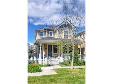 Charming two-story home featuring a classic white picket fence and lovely front yard landscaping at 2846 Central Park Blvd, Denver, CO 80238