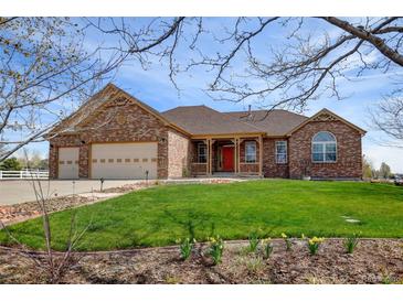 Charming single-Gathering home featuring a brick facade, well-manicured lawn, and a three-car garage at 16350 Timber Cove St, Hudson, CO 80642