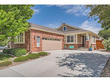 Charming brick home featuring a two-car garage and a well-manicured front yard at 20058 E Dartmouth Dr, Aurora, CO 80013