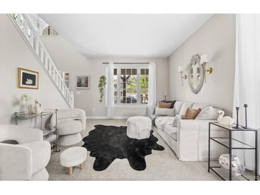 Bright living room features a modern design with a plush sofa, statement rug, and ample natural light from a large window at 20740 Parker Vista Rd, Parker, CO 80138