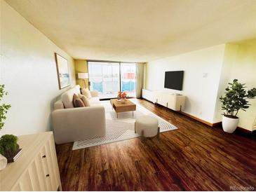 Bright living room featuring a sliding door to a balcony, hardwood floors, and comfortable seating arrangements at 1155 N Ash St # 908, Denver, CO 80220