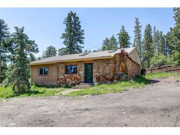 Charming stone and wood cabin featuring rustic details and a natural setting at 10893 Milliken Ave, Conifer, CO 80433