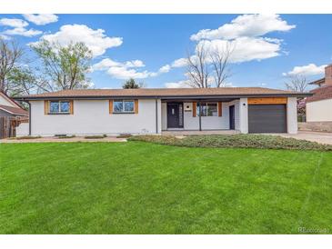 Charming single-story home with a well-manicured lawn, and a one car garage at 8622 W Warren Ln, Lakewood, CO 80227