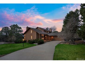 Stunning exterior elevation of home with a beautiful driveway and colorful sunset backdrop at 6275 Lakewood Rd, Parker, CO 80134