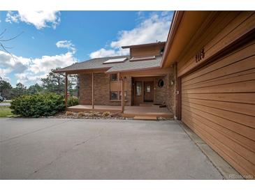 Charming single-Gathering home featuring a brick facade, covered porch, and an attached two-car garage at 6275 Lakewood Rd, Parker, CO 80134