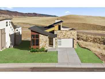 Contemporary stone home featuring a two-car garage and beautifully landscaped front yard, situated on a hill at 5741 Doc Bar Circle, Larkspur, CO 80118