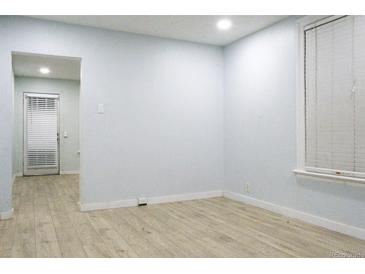 Bright living room featuring wood floors and a window with blinds, offering a clean and inviting space at 3325 Navajo St, Denver, CO 80211