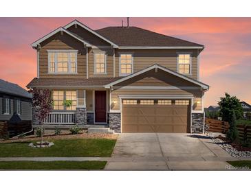 Charming two-story home featuring a two-car garage, covered porch, and beautifully landscaped front yard at 800 Boulder Peak Ave, Erie, CO 80516