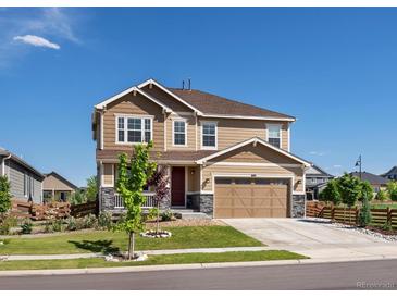 Charming two-story home with a two-car garage, lush lawn, and inviting front porch at 800 Boulder Peak Ave, Erie, CO 80516