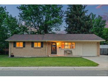 Charming ranch home features a well-manicured front lawn, brick facade, and attached one-car garage at 10844 W 68Th Ave, Arvada, CO 80004