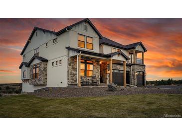 Beautiful two-story home featuring stone accents, a covered porch, and a two-car garage at 8700 Lost Lake Dr, Franktown, CO 80116