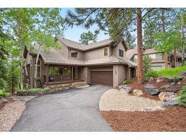 Charming two-story home with a private drive, mature landscaping, and an attached two car garage at 29962 Troutdale Ridge Rd, Evergreen, CO 80439