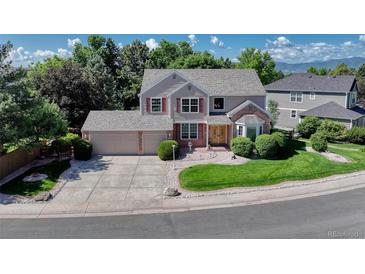 Charming two-story home boasts mature landscaping, a two-car garage, and inviting curb appeal at 10142 Mountain Maple Dr, Highlands Ranch, CO 80129