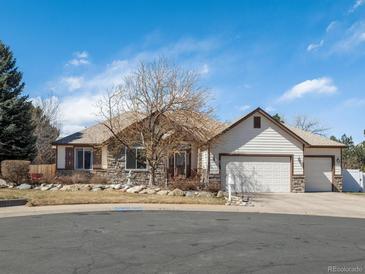 Charming single-story home featuring a stone facade, manicured lawn, and an attached two-car garage at 5175 Quari St, Denver, CO 80239