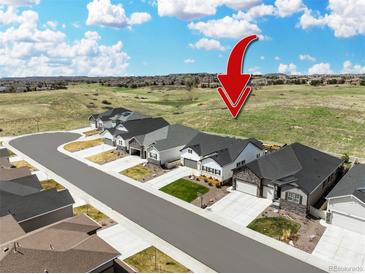 An exterior street-view of modern, suburban homes with a scenic view and arrow graphic at 5707 Cadara Way, Parker, CO 80134