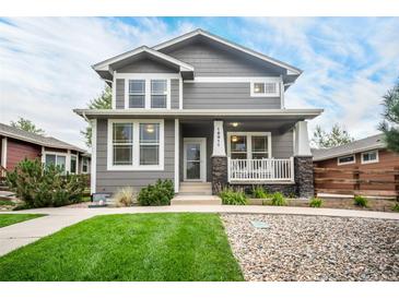 Two-story gray house with white trim, front porch, and landscaped lawn at 16911 Buffalo Valley Path, Monument, CO 80132