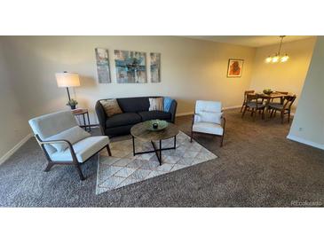 Cozy living room features comfortable seating and decorative artwork in a warm and inviting setting at 7695 E Quincy Ave # 207, Denver, CO 80237