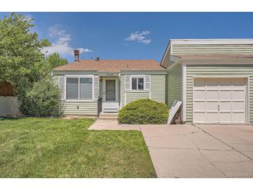 Charming single-story home with light green siding, well-kept lawn, and a detached single car garage at 16149 E Rice Pl # A, Aurora, CO 80015