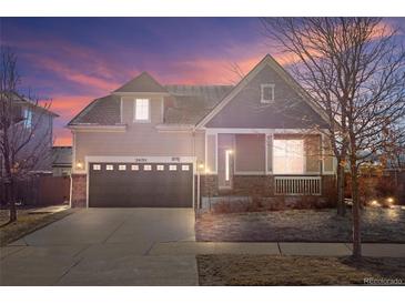 Charming single-Gathering home featuring a two-car garage, covered porch, and well-maintained landscaping at twilight at 24192 E Alamo Dr, Aurora, CO 80016