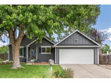 Charming gray single Gathering home featuring a two-car garage and beautifully manicured lawn at 18056 E Bellewood Dr, Aurora, CO 80015