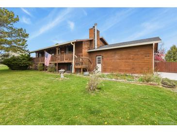 Charming wood-sided home with a spacious lawn, and inviting balcony, perfect for outdoor living at 34101 Columbine E Trl, Elizabeth, CO 80107