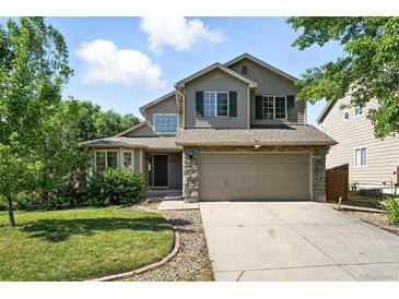 Charming two-story home featuring a well-manicured lawn, a two-car garage and stone accents at 22501 E Belleview Pl, Aurora, CO 80015