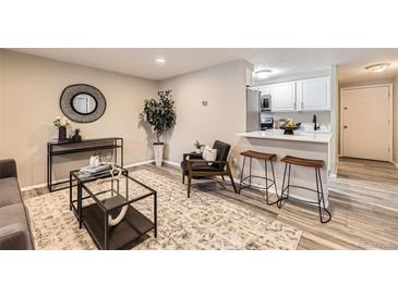 Bright living room with kitchen bar, modern furniture, and hardwood floors at 625 N Pennsylvania St # 108, Denver, CO 80203