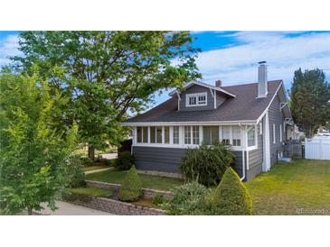 Charming two-story home featuring a mature front yard and covered porch in a well-maintained neighborhood at 4501 Zenobia St, Denver, CO 80212