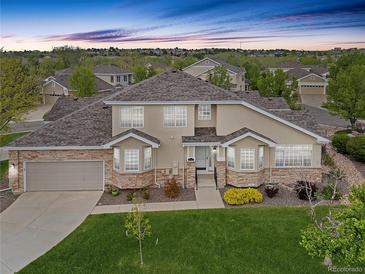Charming two-story home featuring a well-manicured lawn, stone accents, and an attached two-car garage at 22342 E Plymouth Cir, Aurora, CO 80016